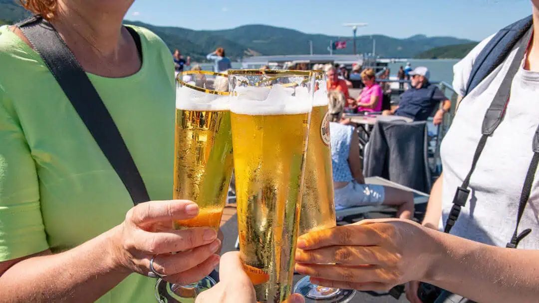 Svalkande öl på soldäck vid båtcykling på Donau