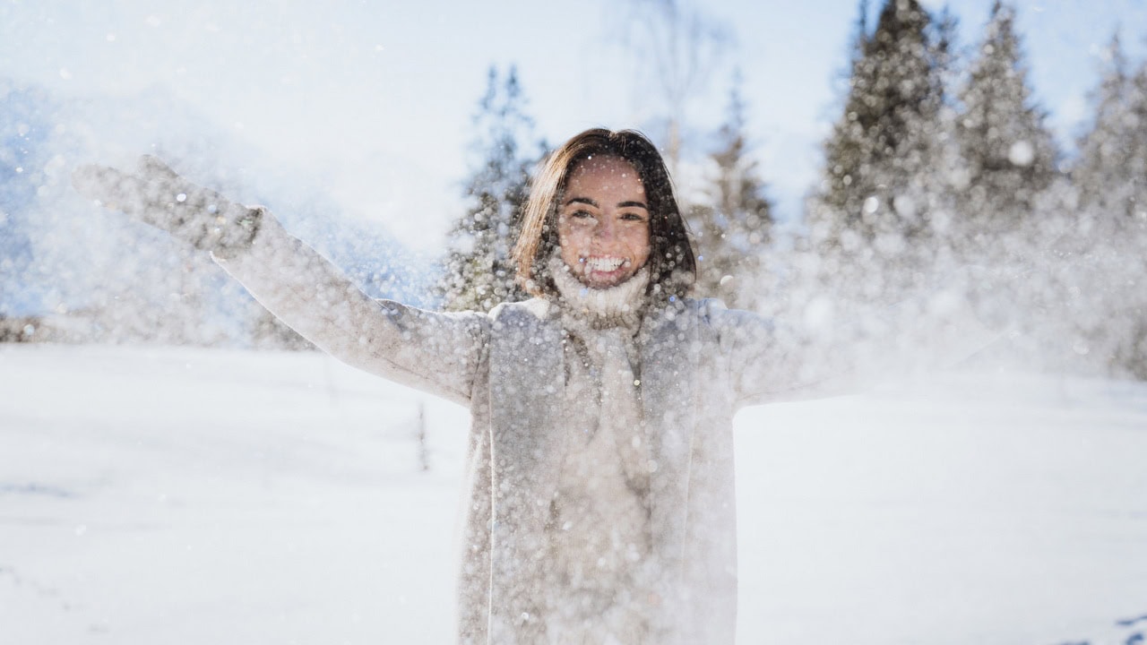 Hitta billig skidresa Alperna Ung kvinna i snö Saalfelden Leogang